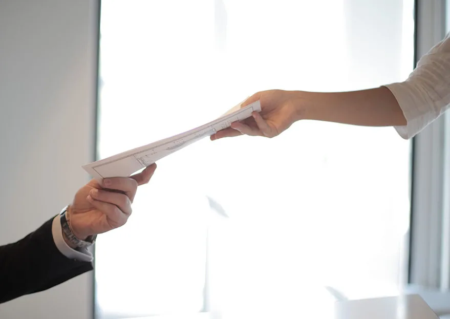 Person modtager ansøgning i hånden